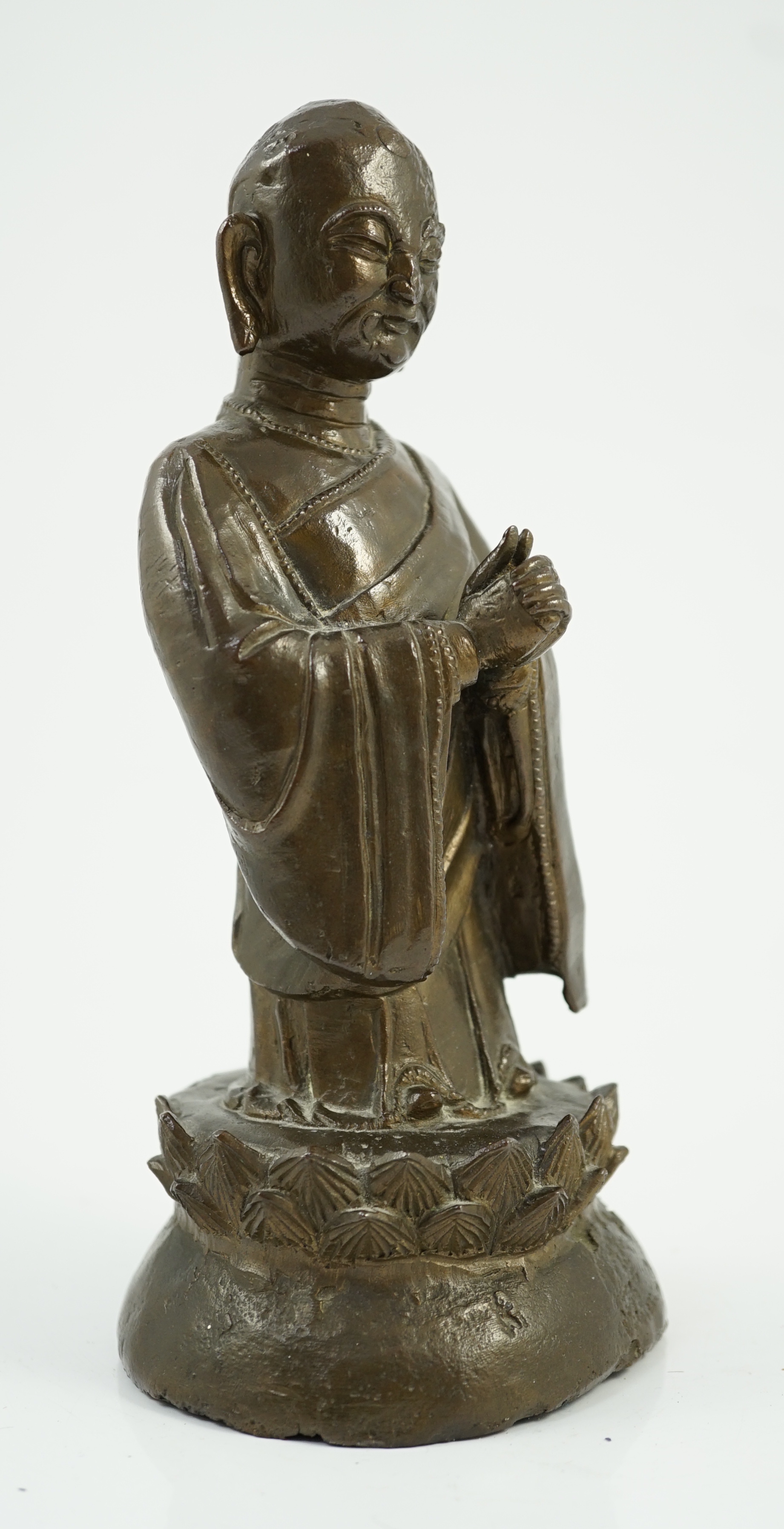 A Chinese bronze figure of a standing luohan, late Ming dynasty, some dents